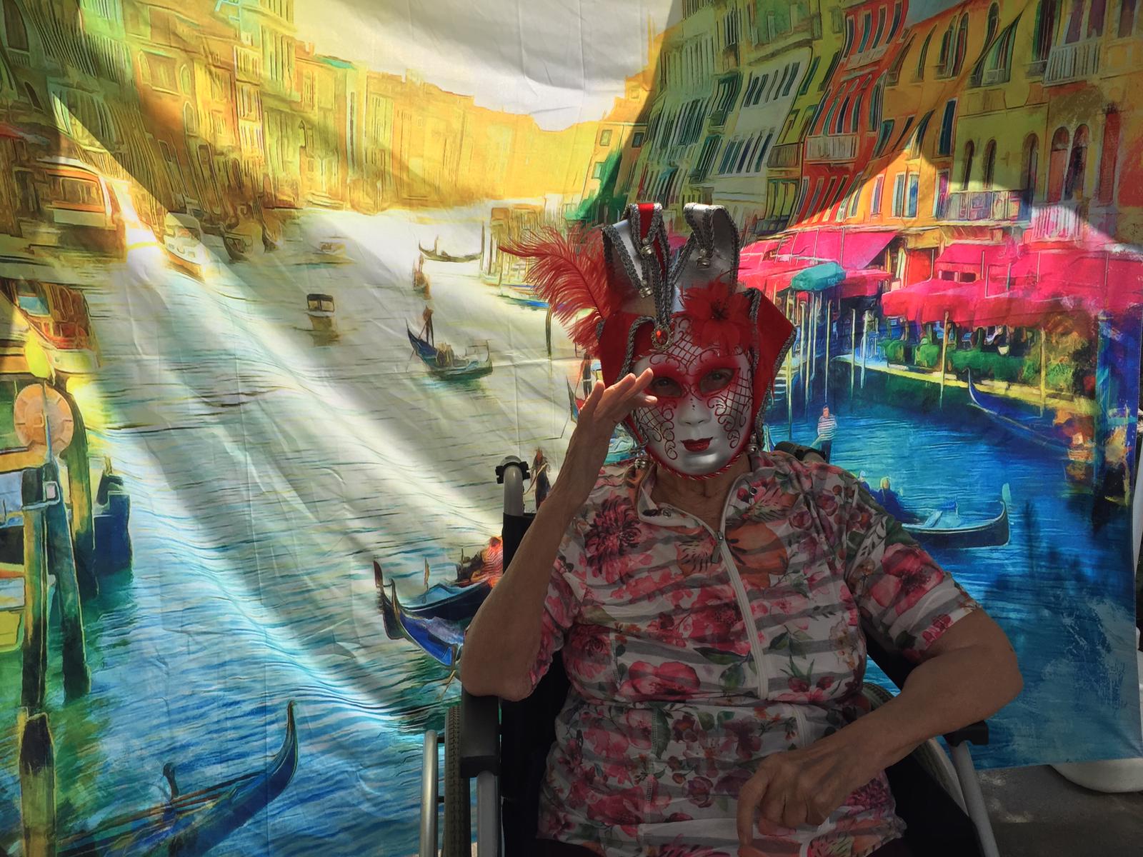 Bewohnerin mit Maske winkt bei der italienischen Woche - Venedig im Seniorenzentrum AGO Trier 