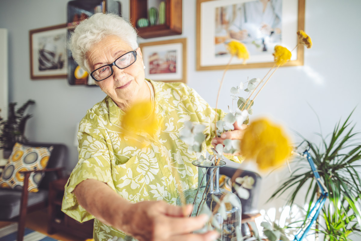 Seniorin dekoriert ihr Zimmer in einem Alloheim Altenheim und sorgt so für mehr Wohnqualität